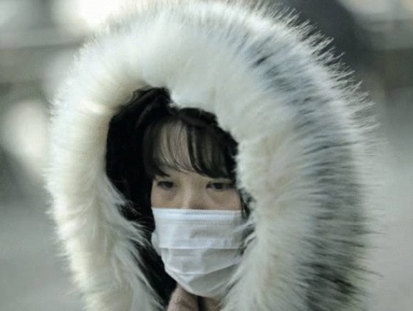 Chinesa se protege do frio e do coronavírus